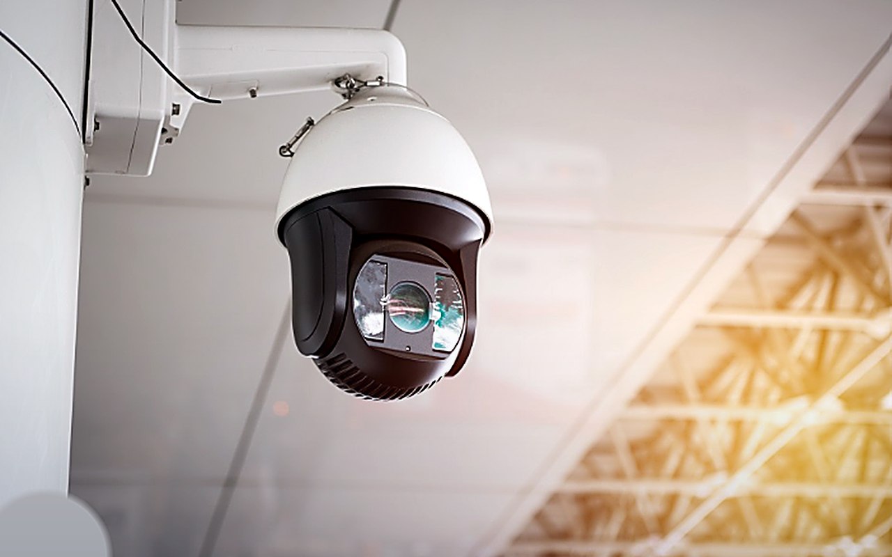 Câmara de videovigilância tipo dome montada no teto de um espaço industrial